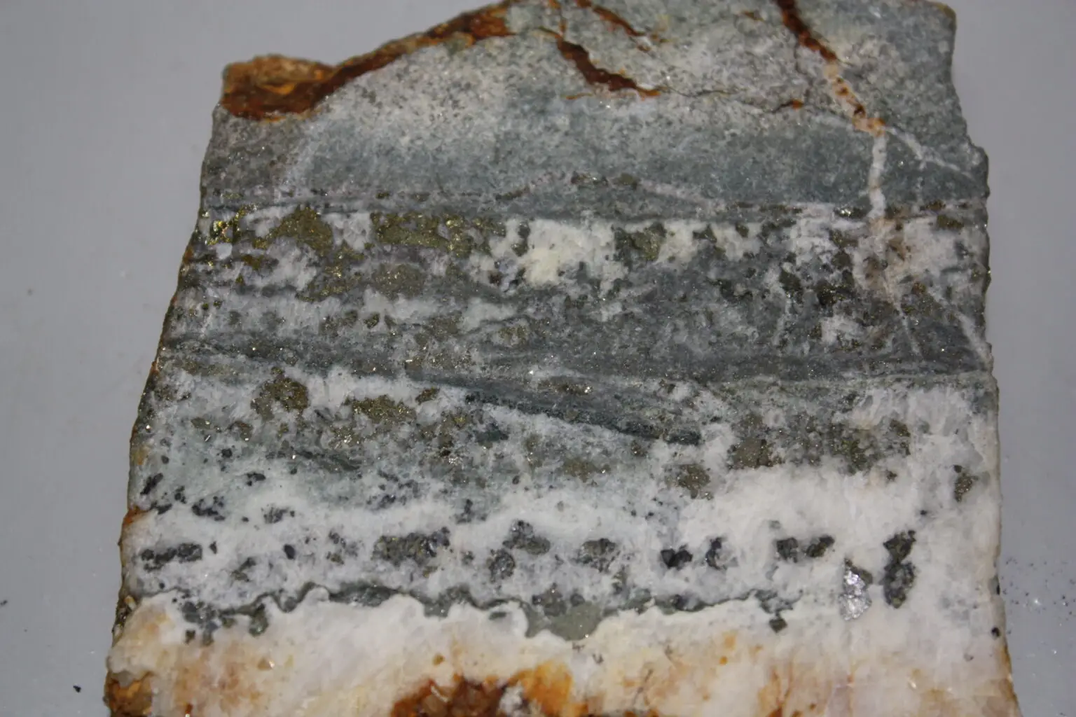 Figura 3f. Cuarzo (blanco) con sulfuros. Yacimiento epitermal de baja sulfuración. Cátedra de Yacimientos, UBA.